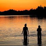 Zwei Badende im Staffelsee bei Sonnenuntergang
