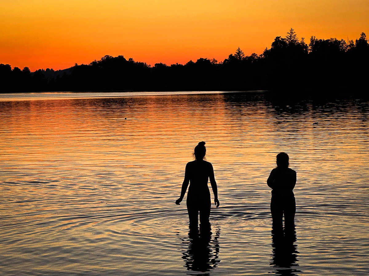 Zwei Badende im Staffelsee bei Sonnenuntergang